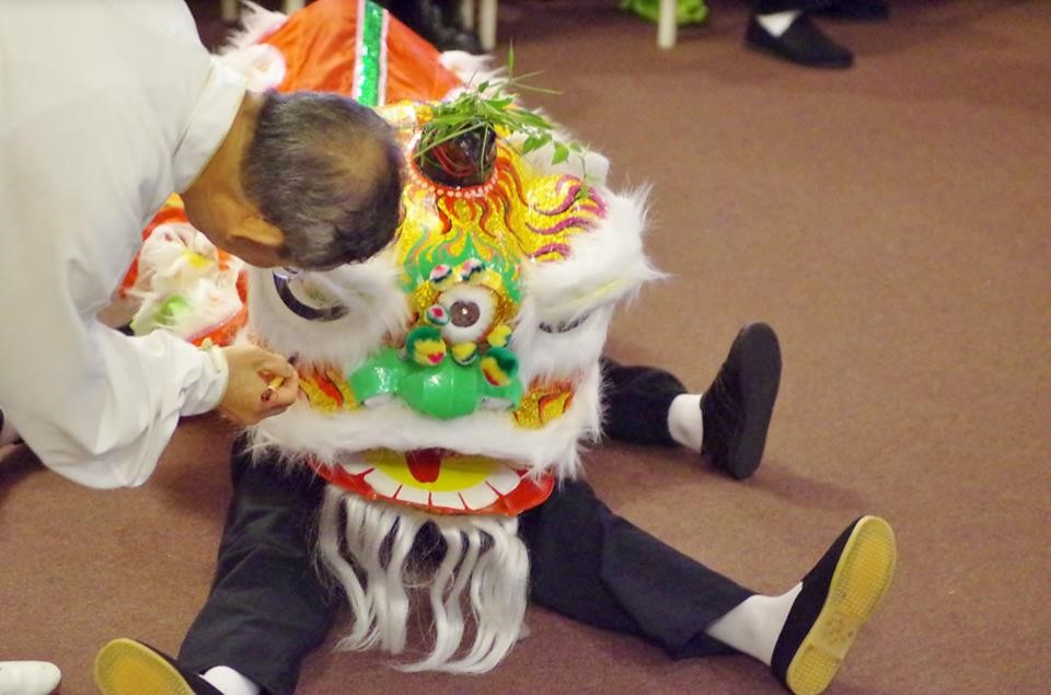 Sifu dotting the eyes of the new lion (James and Cian in the lion).